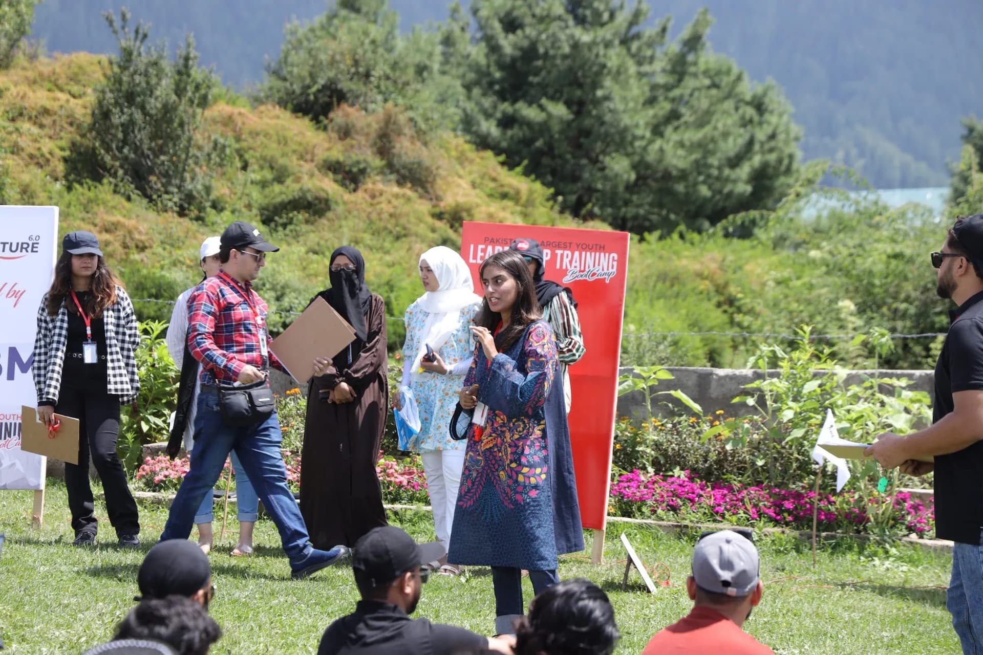 Lalain speaking to a seated group outdoors at a Youth Impact leadership bootcamp